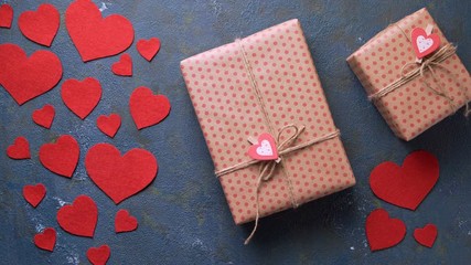 Wall Mural - Valentine's Day holiday gift box concept of romantic love surprise appears in frame on vintage blue table with red hearts decorations flat lay. Blank space for design