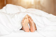 © Southtownboy Studio - Woman feet under white blanket side view. Beautiful young woman feet with blue pedicure on the bed. Sleeping woman legs under the white blanket