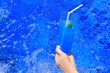 Blue soda soft drink in hand on swimming pool background