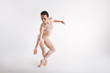 Peaceful young gymnast acting against white background