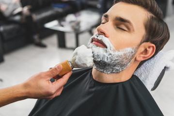 Wall Mural - Skillful beautician preparing to shave stubble