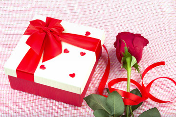 gift box and rose on a light background.