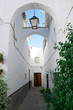 Andalusian white towns: Arcos de la Frontera, scenic alley and a half-open door