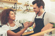 © Yakobchuk Olena - Happy female and male baristas joying at work station