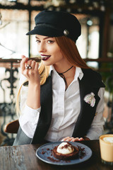 Wall Mural - Stylish fashion beautiful girl eating chocolate desert brown with white cream