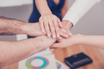 Poster - Close up of group of people putting their hands on top of each o