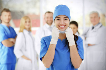 Poster - Young female doctor with colleagues in clinic