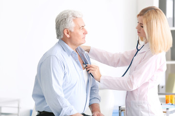 Sticker - Doctor examining aged man in hospital