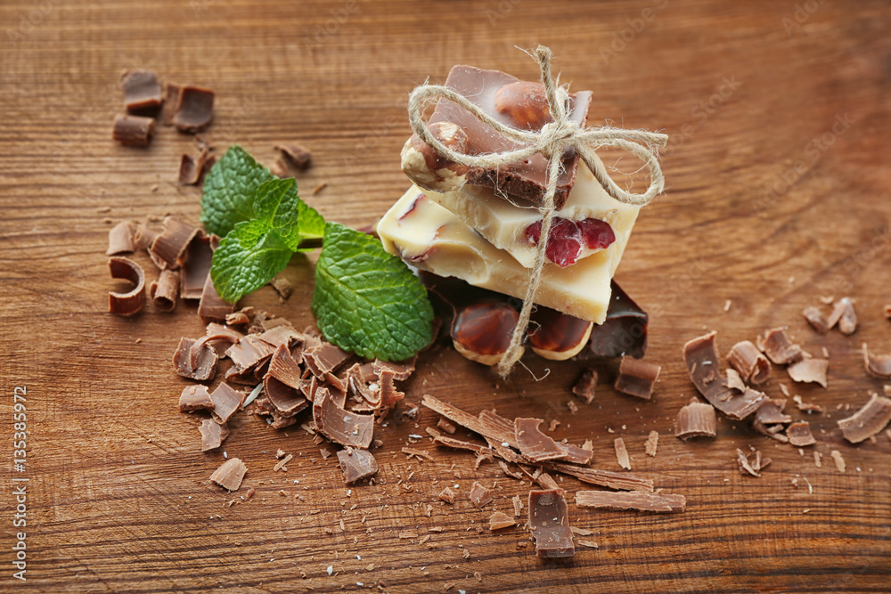 Broken chocolate pieces and shavings on wooden background