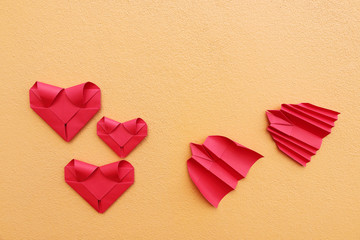 Poster - three folding red paper hearts with bat and bird rocket on yello