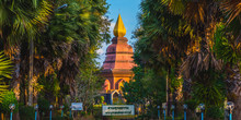 A Stupa Of Wat Phai Lom (a Buddhist Temple In Trat Town, Thailand) Gilded By The Sunset. The Palm Tree Alley Leads To It