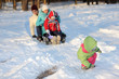 © ruslimonchyk - family of four has fun in the snow in winter