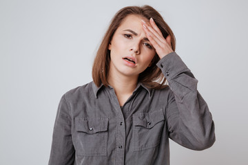 Wall Mural - Sick young woman with headache touching her head.