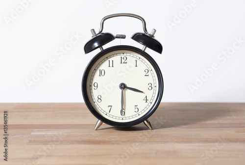 It is half past three o'clock. The time is 3:30. Retro clock isolated