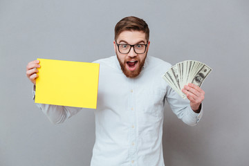 Wall Mural - Shocked smiling businessman holding copyspace blank and money