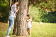 © BalanceFormCreative - Mother and daughter play hide and seek at the park.
