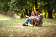 © BalanceFormCreative - Mother and daughter relaxing in park.She reading a fairytale to her daughter
