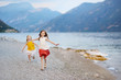 © MNStudio - Two cute little sisters having fun on a beach of Limone sul Garda, a small town and comune in the province of Brescia, Italy