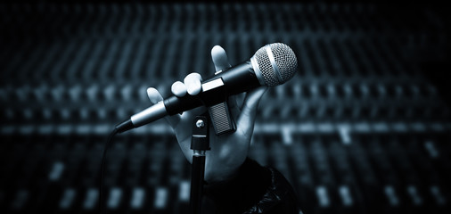 Sticker - singer hands holding microphone on studio mixer background. hands sign mean love,  concept = love to sing