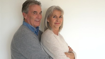 Wall Mural - Senior couple standing on white background