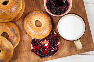 Fresh homemade Poppy bagels bread with cup of milk, cream cheese