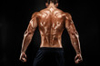 © zamuruev - The back view of torso of attractive male body builder on dark background.