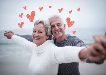 Wall Mural - Portrait of senior couple standing with arms outstretched