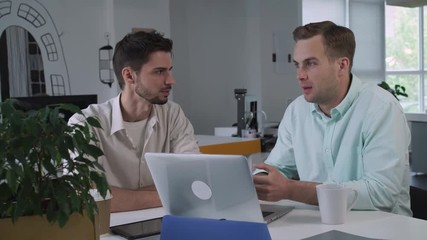 Aufkleber - business meeting in the office. Two men talking smiling sitting at working place debate about some point in project. casual interior.