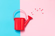 Colorful Watering Can on Colored Background with Sweethearts. Fl