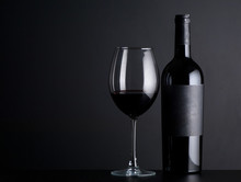 Bottle Red Of Wine With A Glass On A Black Background
