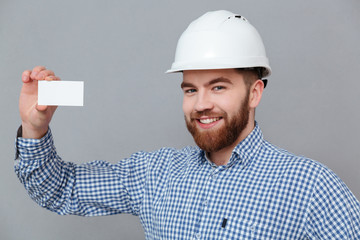 Wall Mural - Happy bearded builder holding copyspace business card