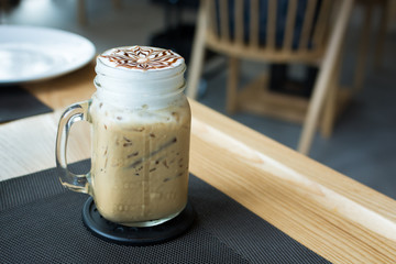 Wall Mural - A glass of ice cappuccino art with foods on table