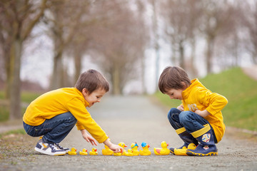 Sticker - Two adorable children, boy brothers, playing in park with rubber