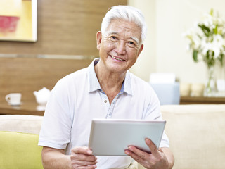 senior asian man using tablet computer