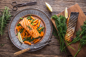 Wall Mural - Salmon fillets. Grilled salmon, sesame seeds herb decoration on vintage pan or black slate board. fish roasted on an old wooden table.Studio shot.