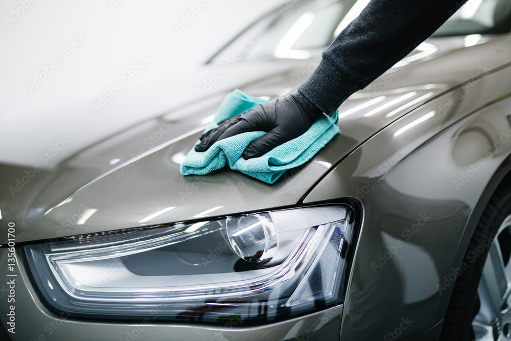 A man cleaning car with microfiber cloth, car detailing (or valeting) concept. Selective focus. - obrazy, fototapety, plakaty 