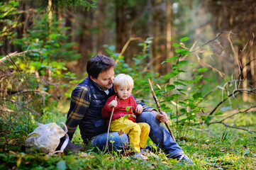 Wall Mural - Father and his son walking during the hiking activities in forest