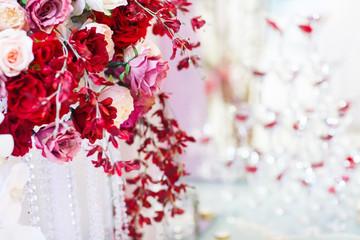 Wedding table decorations. Red roses in a basket sitting on a ta