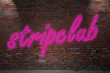 © pixs:sell - Leuchtreklame stripclub an Ziegelsteinmauer