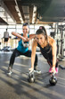 © Bojan - Two sporty girls doing exercises with kettlebells in gym.