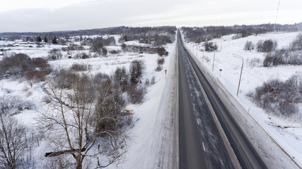 Sticker - Empty snowy slippery federal three line highway passing through the Russian village. Top view