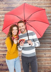 Poster - Portrait of happy couple holding umbrella and maple leaves