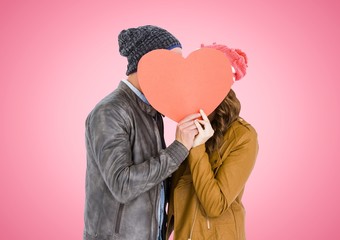 Canvas Print - Couple hiding face behind orange heart