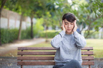 Woman has head ache at the park