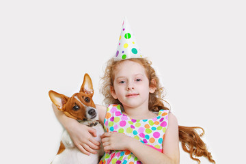 Little girl is smiling and embracing her friend pet, lying on li