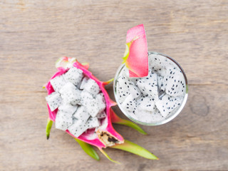 Top view of dragon fruit cutting cube and smoothie on wooden tab