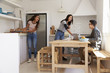 © Monkey Business - Teenagers making lunch and studying together in a kitchen