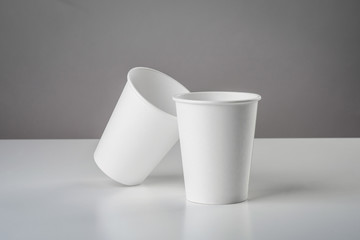 Some white cup with biscuit on gray table