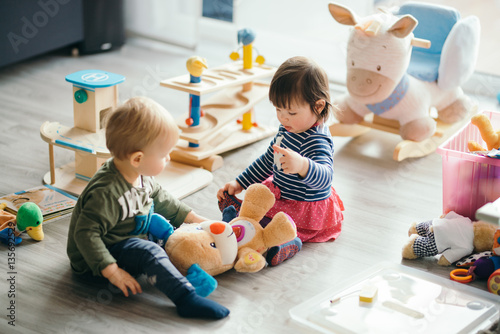 Fotografie, Obraz little girl and boy playing with toys by the home