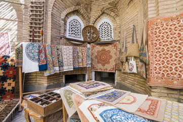 Wall Mural - The wide range of the hand made carpets, traditional knotted Uzbek silk rugs, embroidered tablecloths and bed linen in the small bazaar, Khiva, Uzbekistan, Central Asia